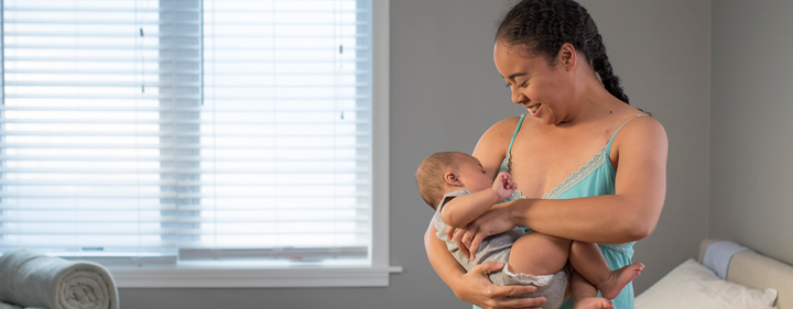 Mom standing breastfeeding baby